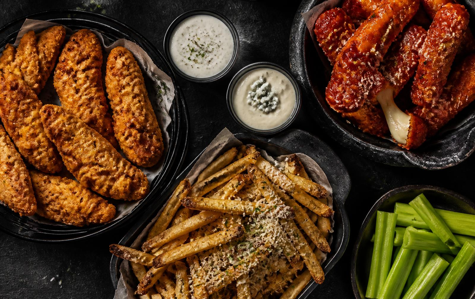 Tenders, garlic parm fries and sauced mozzarella laid out on slate